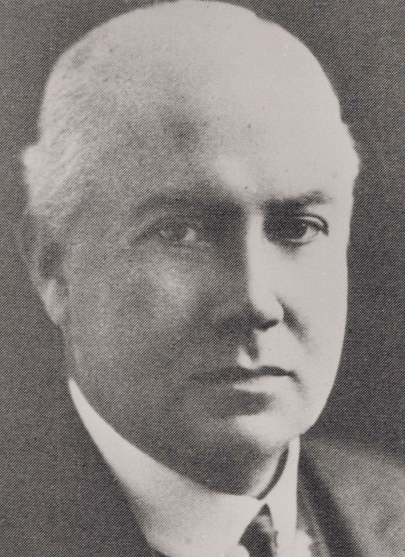 A formal portrait of Dr Mark Cowley Lidwill in a dark suit and tie. Photo courtesy of The Royal Australasian College of Physicians. Photographer unknown. 